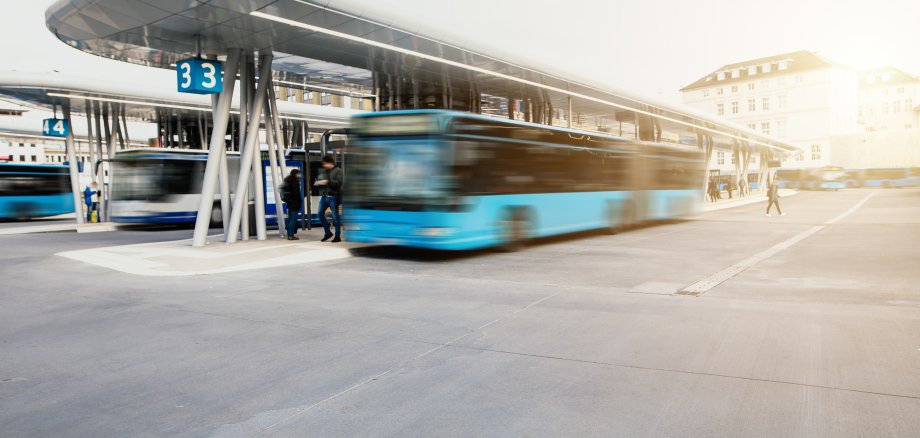 Bus fährt von der Bushaltestelle am modernen Busbahnhof los