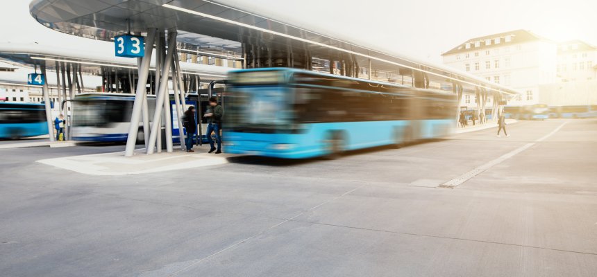 Bus fährt von der Bushaltestelle am modernen Busbahnhof los