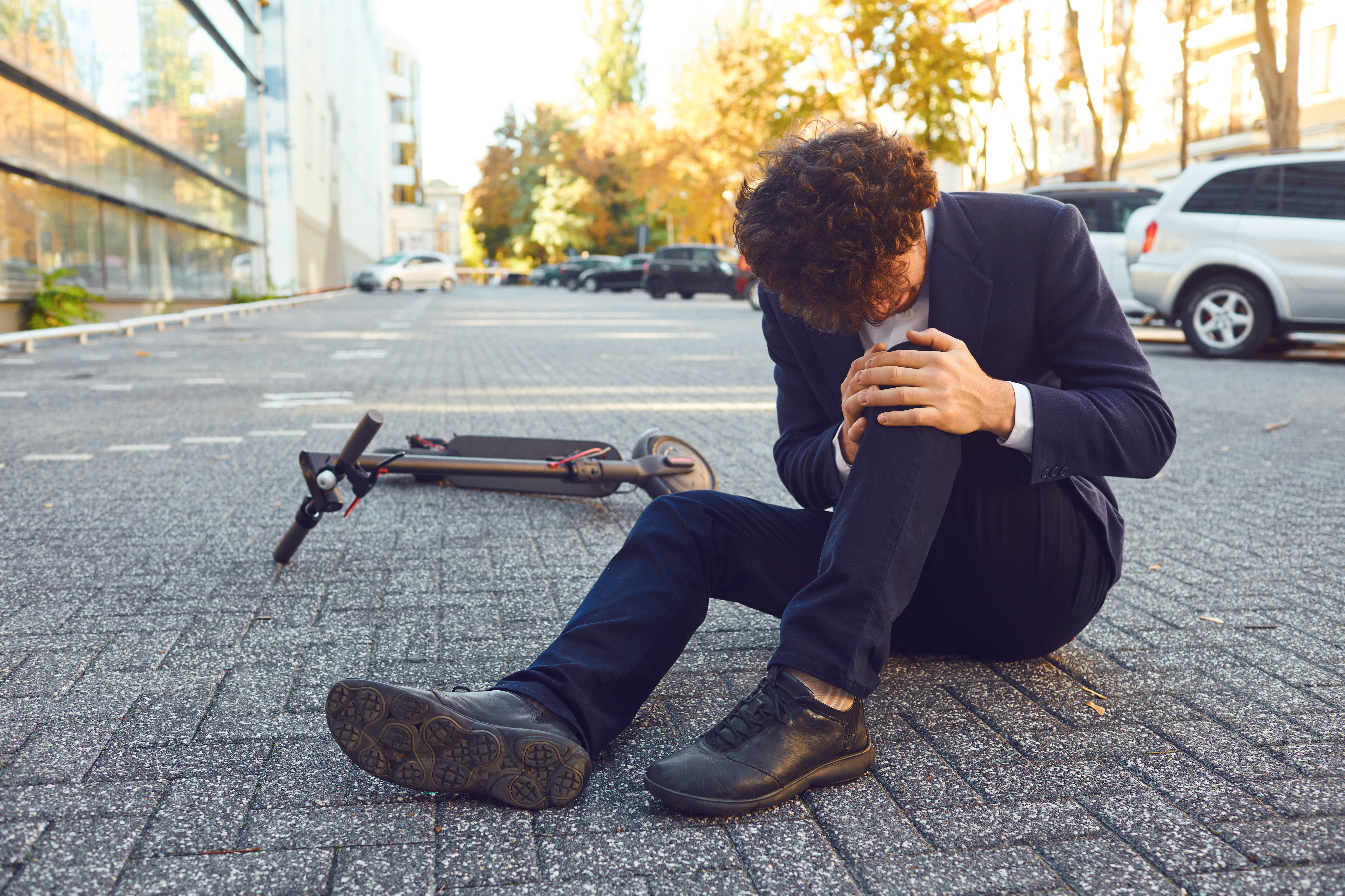 Accident with an electric scooter. A man fell from a scooter on a city street. Ein Mann ist vom Roller gefallen.