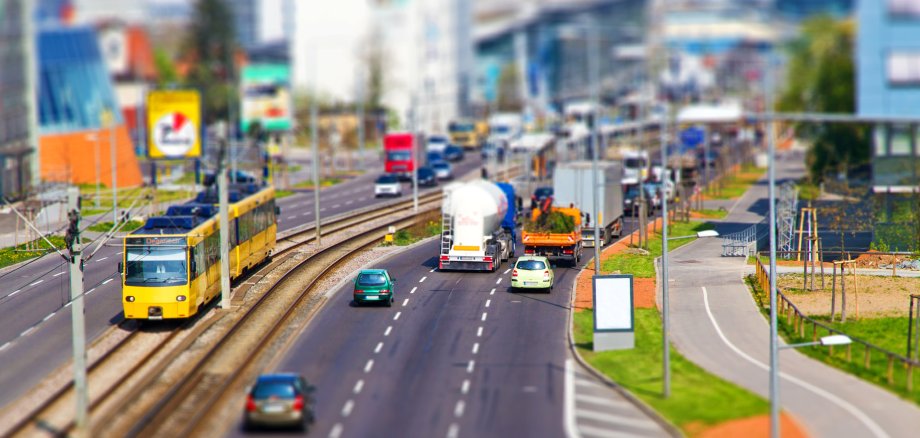 Tageslicht Foto von einer dreispurigen Straße, die parallel zu einer Straßenbahnlinie verläuft.