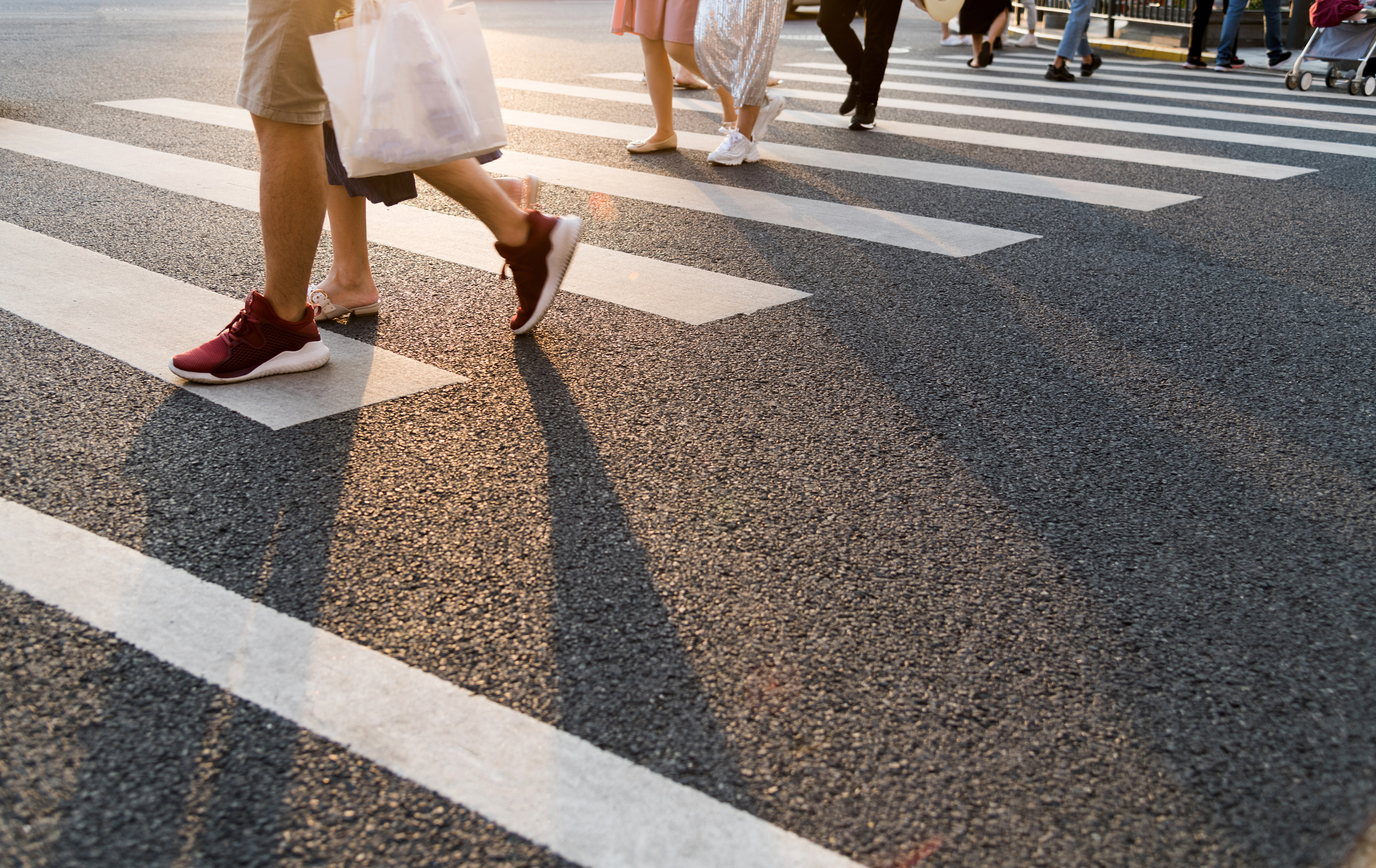 Gruppe von Menschen, die über einen Zebrastreifen gehen