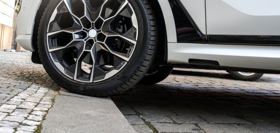 Parked Car with One Wheel on the Curb of City Sidewalk, Incorrect Parking on Pavement with Risk of Ticket, Fine or Penalty