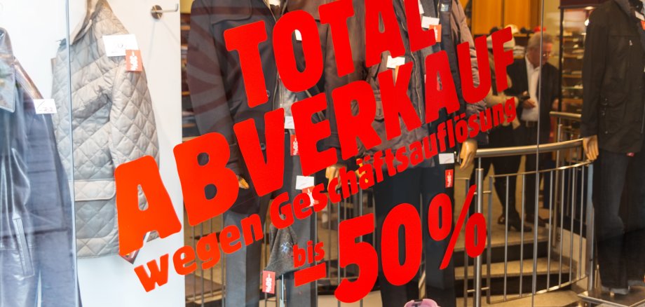 Aufschrift auf Schaufensterscheibe: Totalabverkauf wegen Geschäftsaufgabe -50%