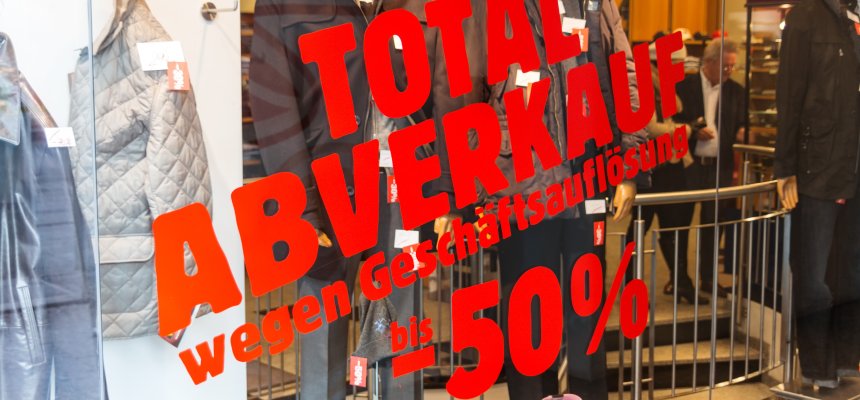 Aufschrift auf Schaufensterscheibe: Totalabverkauf wegen Geschäftsaufgabe -50%
