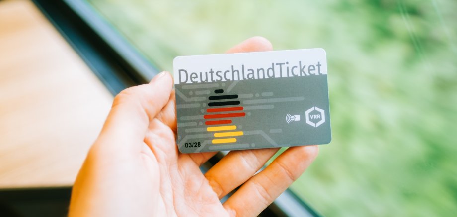 Hand hält DeutschlandTicket des VRR. 