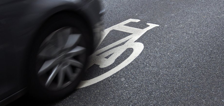 Verkehrssicherheit: Auto auf Fahrbahnmarkierung Radweg