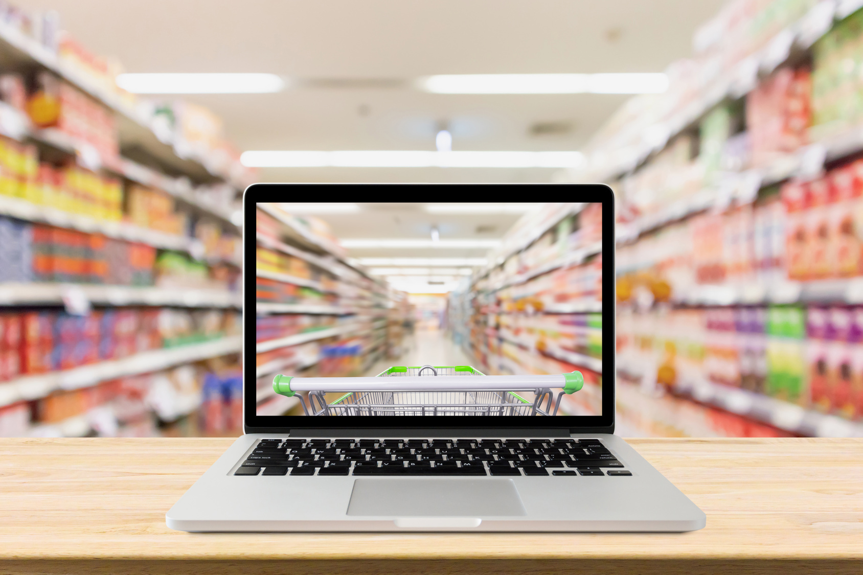 laptop computer on wood table with supermarket aisle blurred background online shopping concept Supermarkt und Laptop