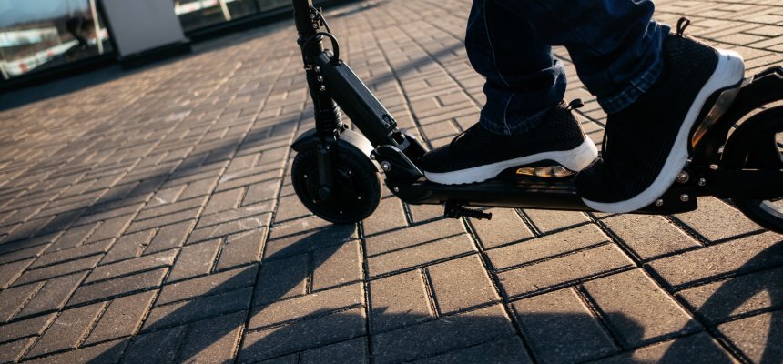 Close up view of legs of man on electric scooter outdoor. Elektroscooter