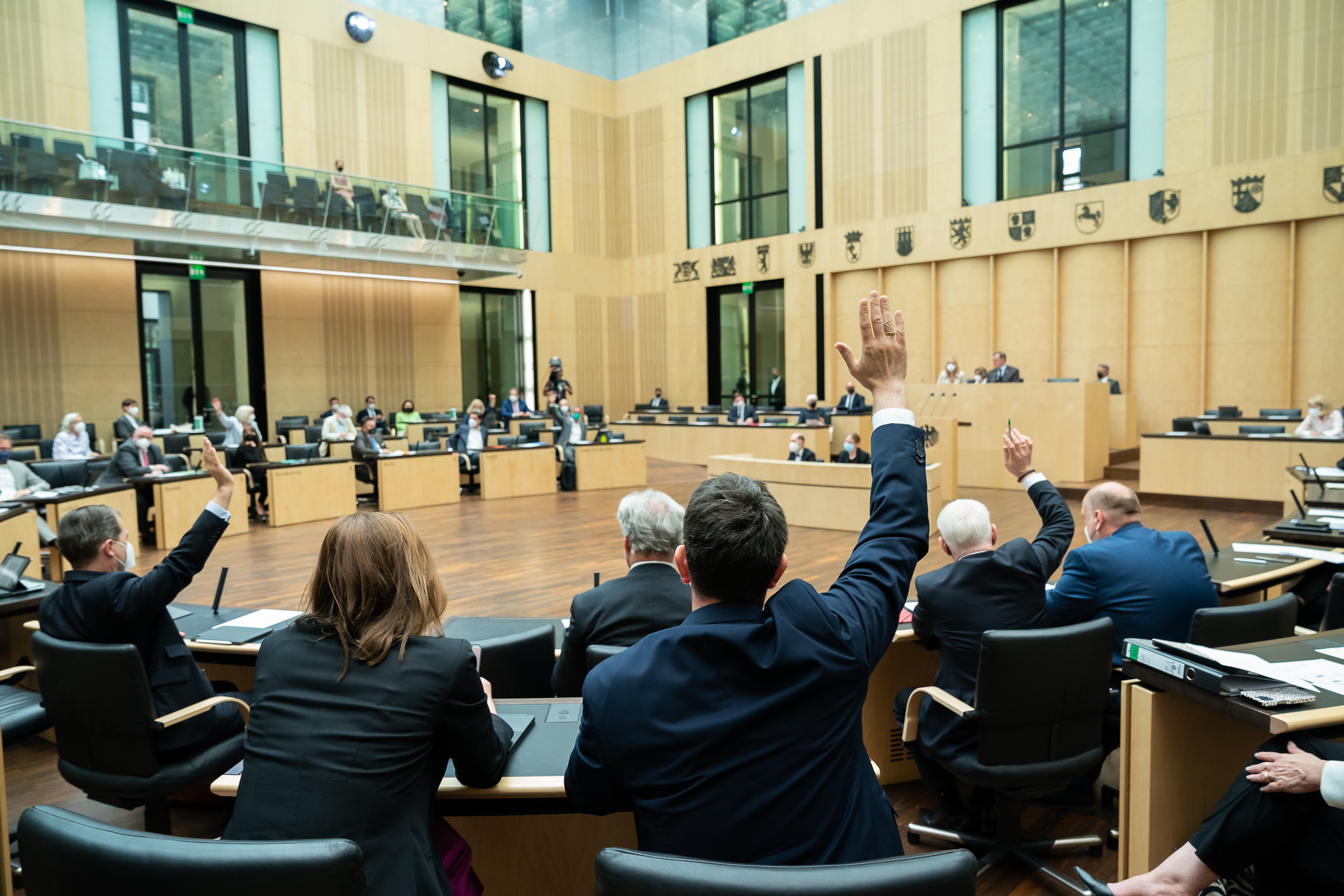 Abgeordnete im Bundesrat heben die Hand zur Abstimmung.
