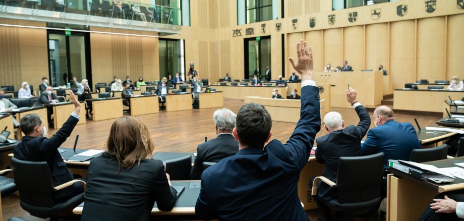 Abgeordnete im Bundesrat heben die Hand zur Abstimmung.