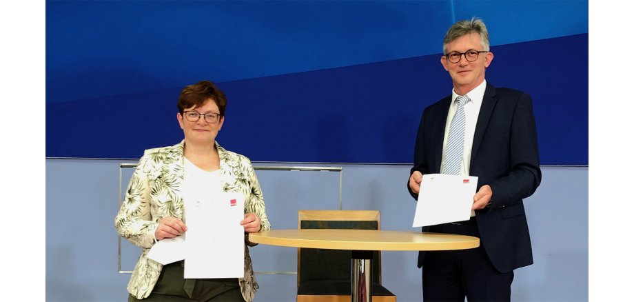 V. l. n. r.: Christine Behle, Stellvertretende Vorsitzende der Vereinten Dienstleistungsgewerkschaft (Verdi) und Ralph Spiegler, DStGB-Präsident und Bürgermeister der VG Nieder-Olm beim Unterzeichnen der Erklärung.