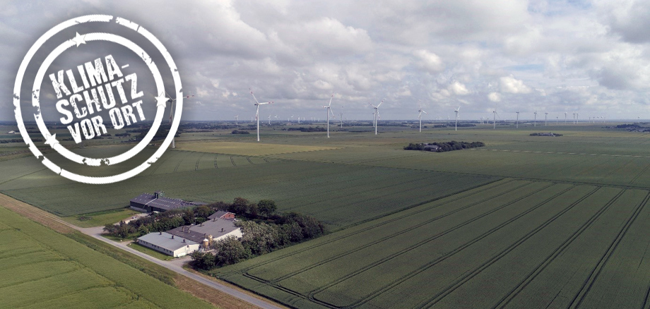 Luftbild aus dem Friedrich-Wilhelm-Lübke-Koog, auf dem ein teilnehmendes Gebäudes der Wind-und-Wärme-Modellregion und Teile des Bürgerwindparks zu sehen sind